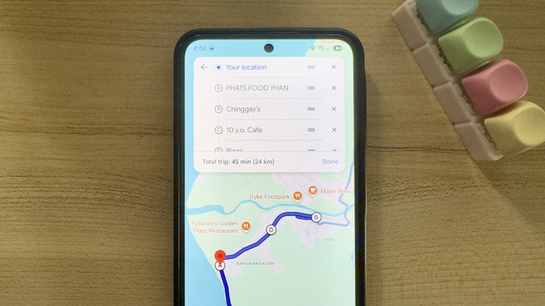 Phone showing Google Maps route planning with stops