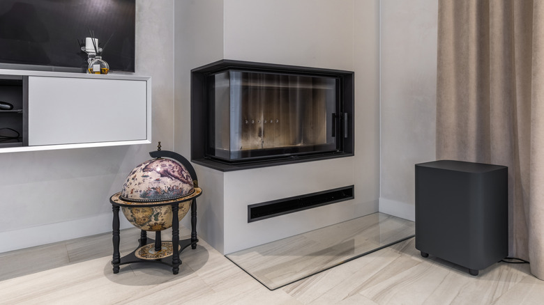 a large subwoofer next to a fireplace and TV inside a home