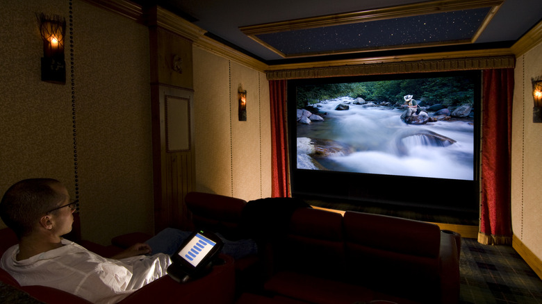 A person watching a movie in a dedicated home theater room.