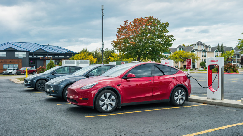 A Tesla vehicle connected to a Tesla Supercharger interface.