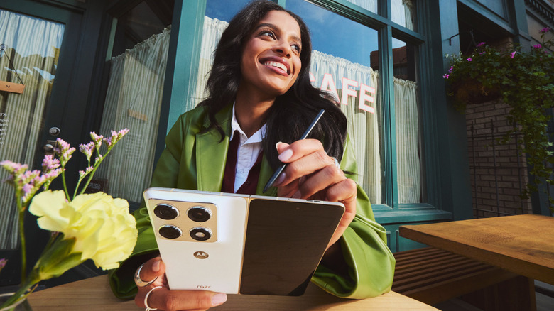 Person using Motorola Fold phone with stylus