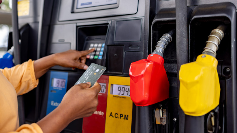 Someone paying at a gas pump