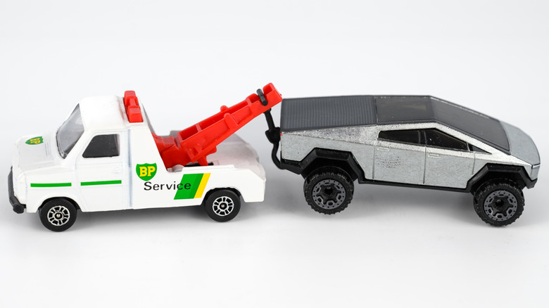Toy Tesla Cybertruck being towed by a BP service matchbox