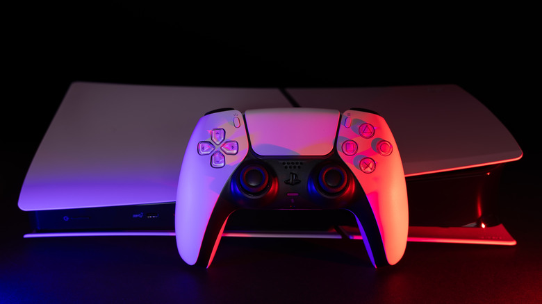 A PS5 controller sitting in front of the console in a dark environment