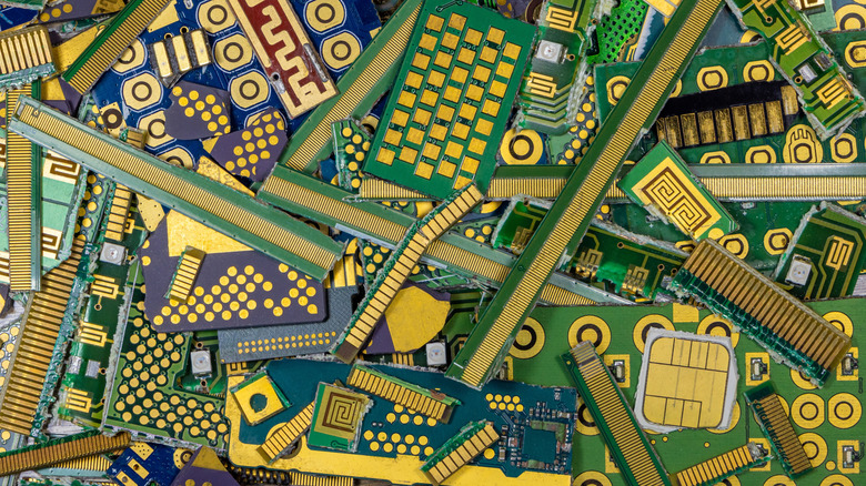 A pile of printed circuit boards with gold layers on them.