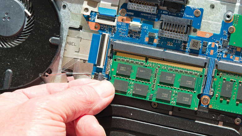 The inside a laptop with RAM module and circuit board visible.