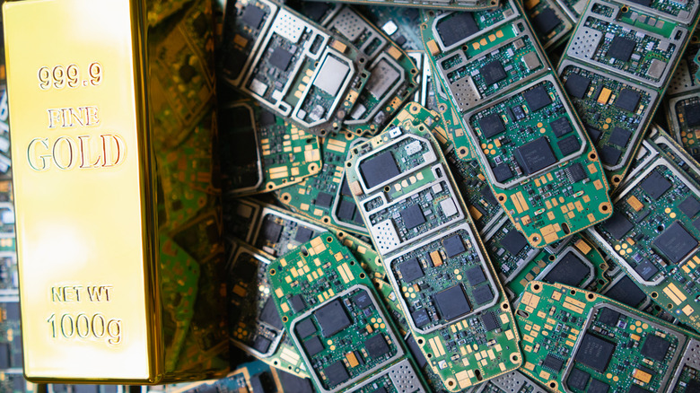 Fine gold bar resting atop computer circuit boards and gadgetry.