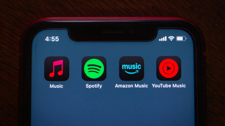 Close-up of icons of Apple Music, Spotify, Amazon Music, and YouTube Music services on a phone