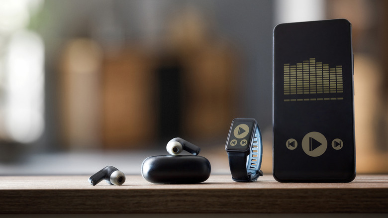 An EQ app on a phone next to a set of earbuds.