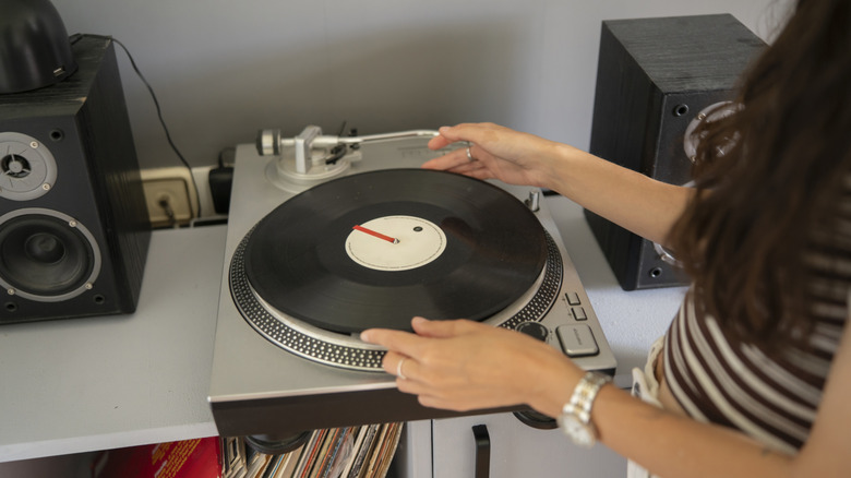 A person setting a record onto a turntable.