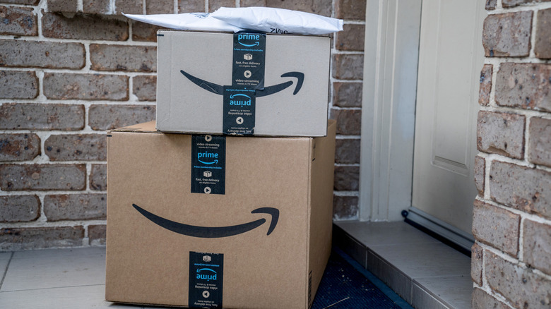 Amazon Prime packages stacked on top of each other at someone's front door.