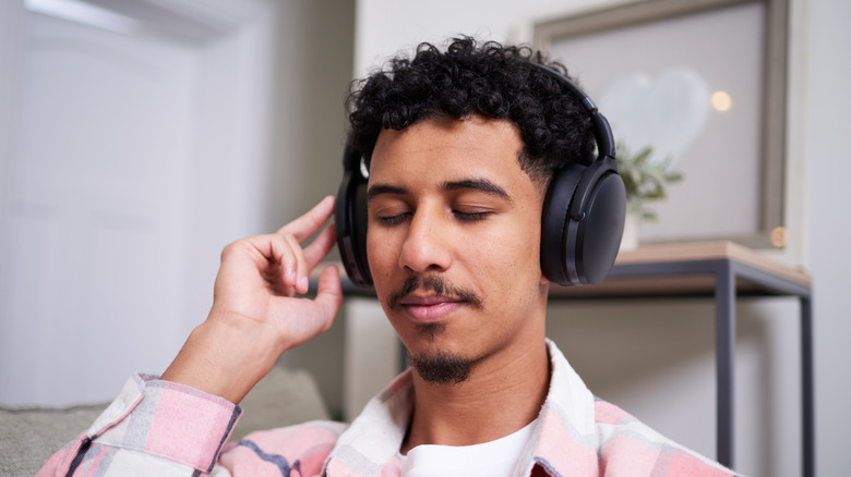 A man wearing a pair of noise cancelling headphones.