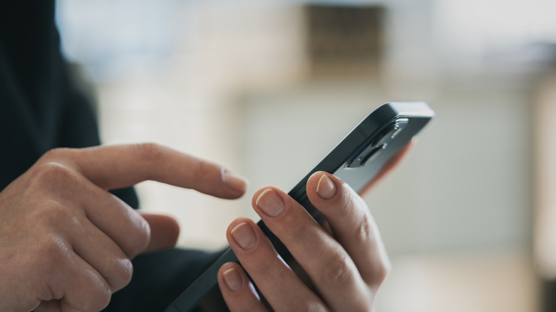 A man's hands on a phone.