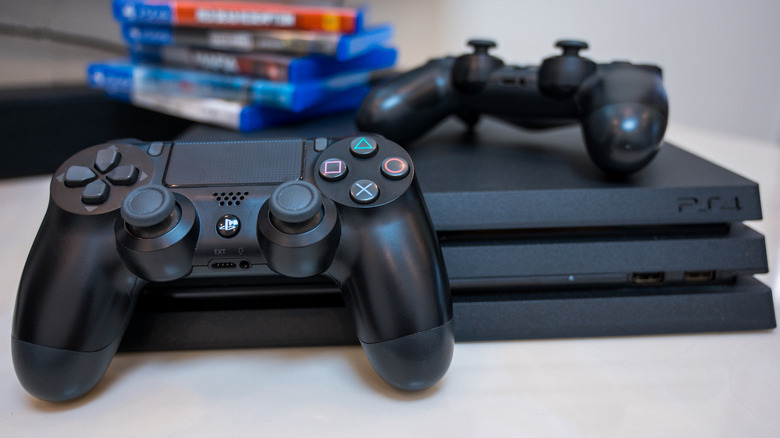 Two controllers next to a last-gen PlayStation 4 Pro console