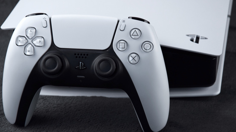 Close-up of DualSense controller in front of a PlayStation 5 console.