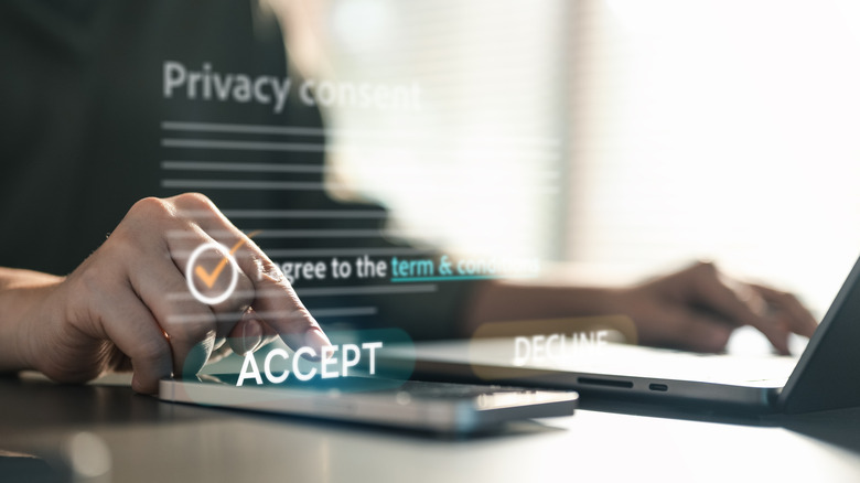 Person using computer and phone accepting privacy terms and conditions