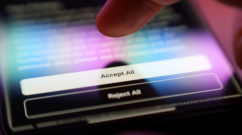 Close-up of phone screen with person selecting Accept All cookies
