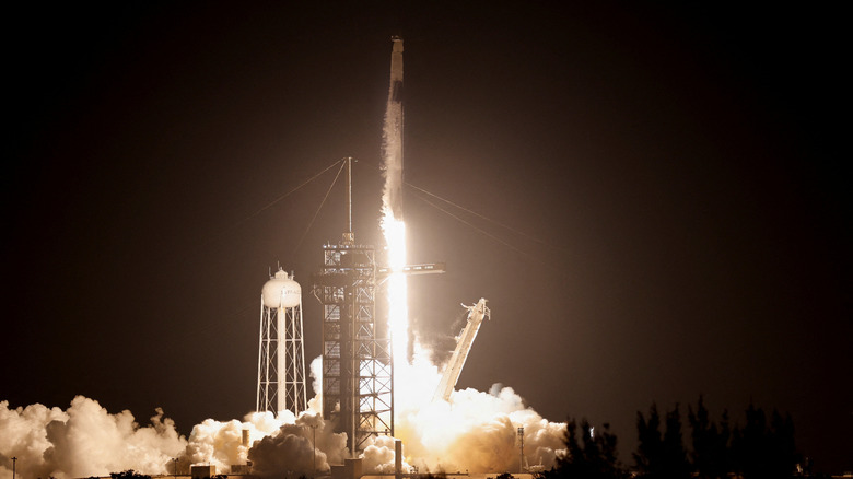 spacex falcon 9 rocket taking off from launchpad in the middle of the night