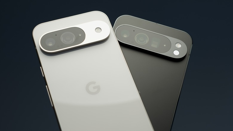 A silver Google Pixel 9 on top of a black Google Pixel against an all-black background