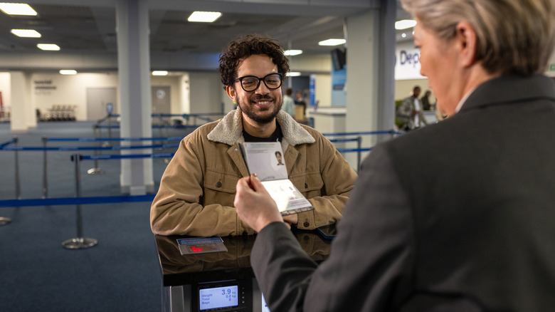 TSA agent checking a traveller's passport at a security checkpoint