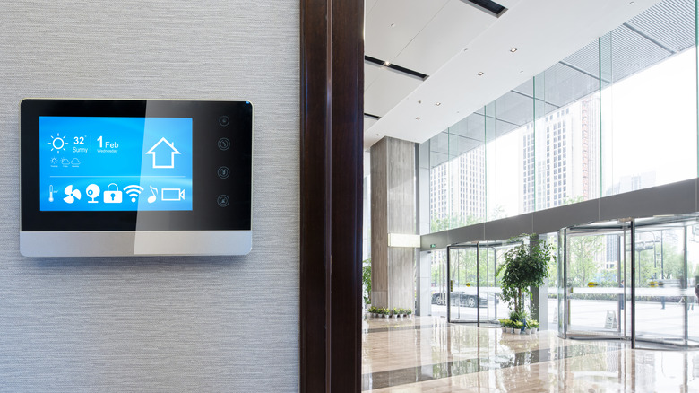 Smart home controller installed on a wall of a modern home.