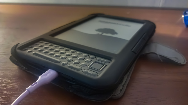 Older model Kindle with keyboard on table.