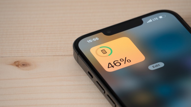 An iPhone with the battery percentage widget kept on a wooden table