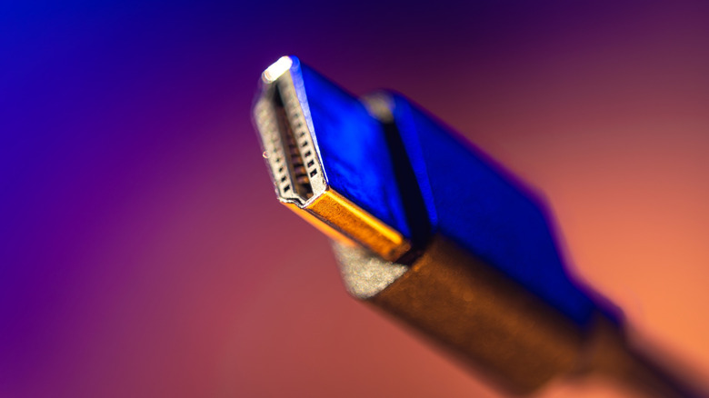 Close-up of an HDMI connector with a neon background