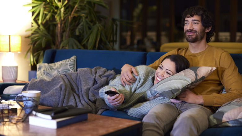 a happy couple on the sofa watching TV