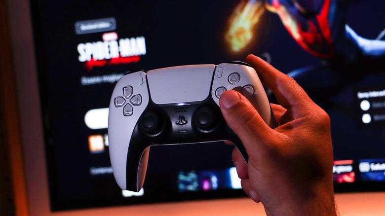 An image of a hand holding a DualSense controller.