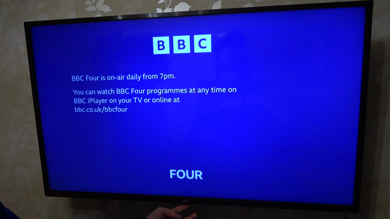 Person pressing LG TV's physical button