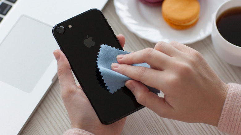 Wiping an iPhone with a microfiber cloth