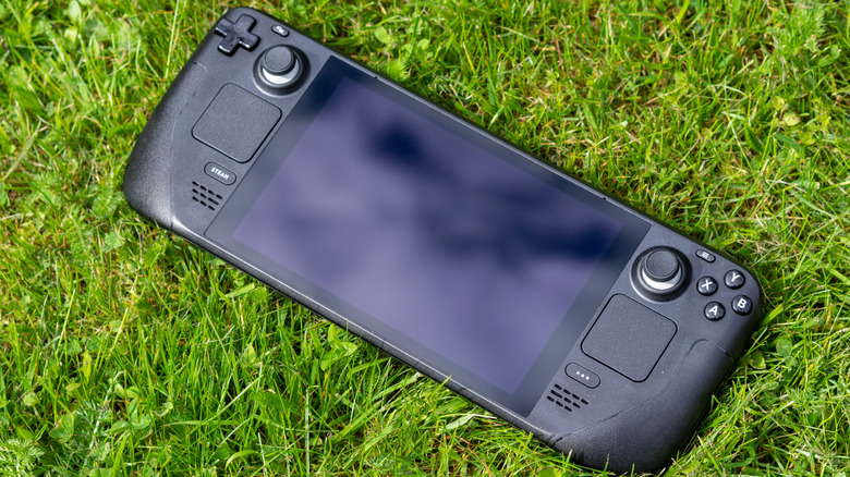 Steam Deck console laying on grass