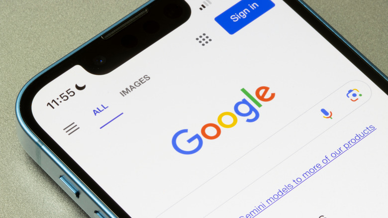A closeup of an iPhone displaying the Google home page