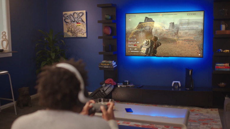 Man playing games on PS5 under TV