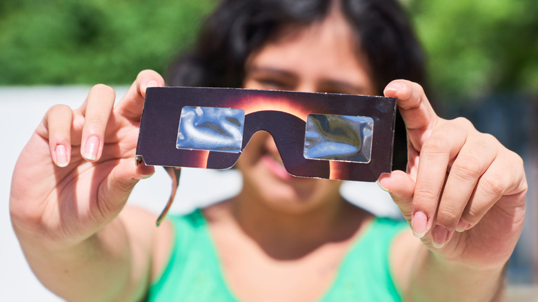 Person examining authentic solar eclipse glasses