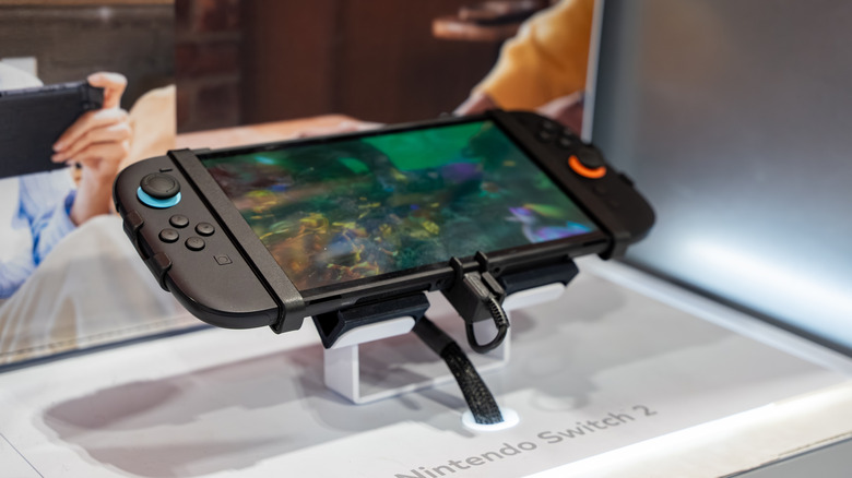 Nintendo Switch 2 handheld console displayed on a demo stand with gameplay on screen.