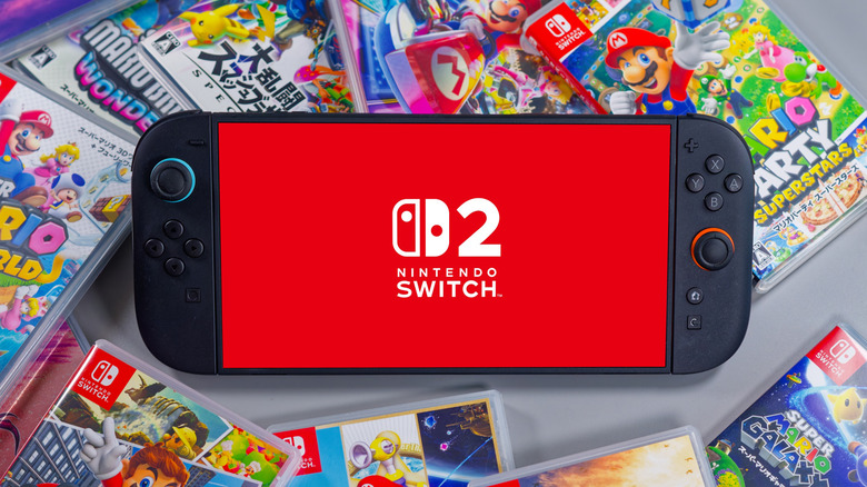 Nintendo Switch 2 console displaying logo surrounded by physical game cases on a table.
