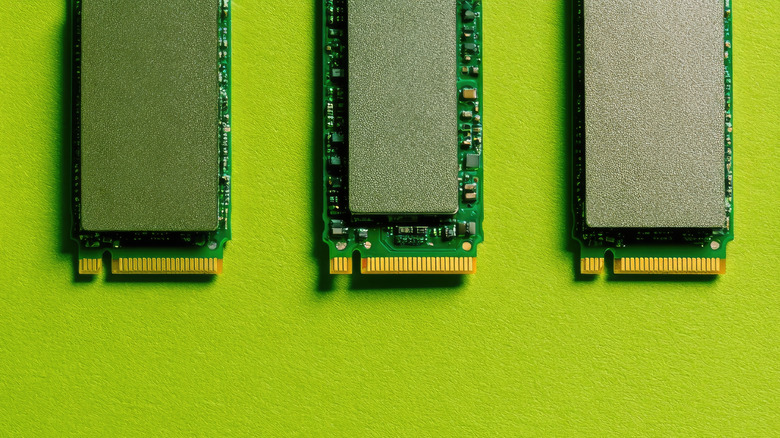 Three NVMe SSDs in front of a green background