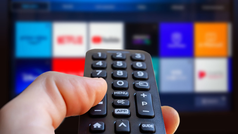 Close up of a TV remote pointed at a screen with a list of streaming apps