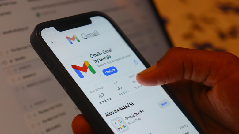 A person holding an iPhone with the Gmail app on the screen