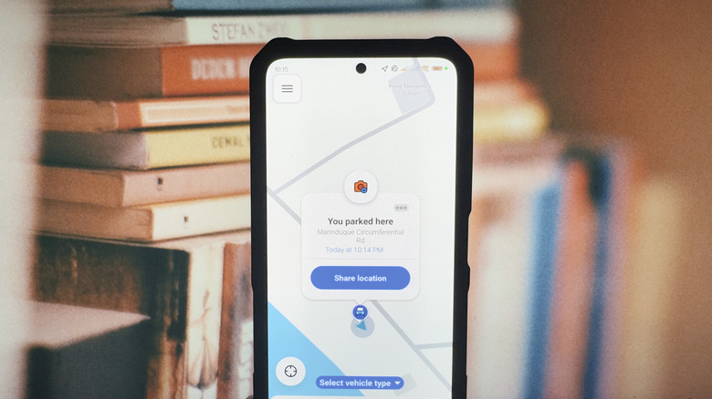 A phone showing a saved parking location on the Waze app