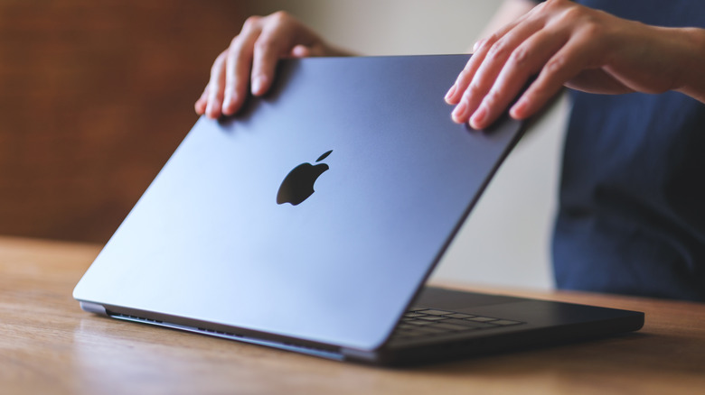 Person closing gray MacBook