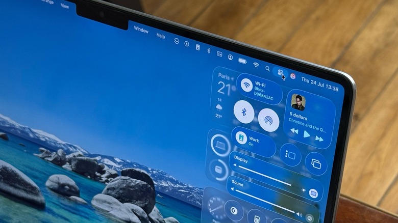 A close-up shot of a MacBook Pro's Control Center against a wooden table background