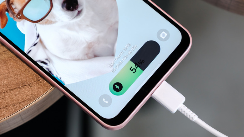 A Samsung Galaxy smartphone plugged in and charging.