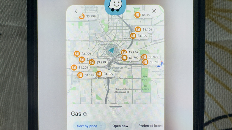 A phone showing Waze with prices at gas stations displayed in 