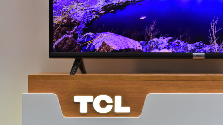 A stand displaying a TCL TV with the TCL logo visible underneath it.