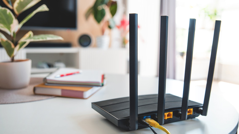 A Wi-Fi router on a desk near plants