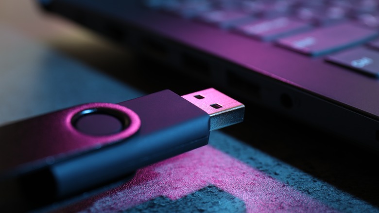 USB drive plugging into a port on a laptop.