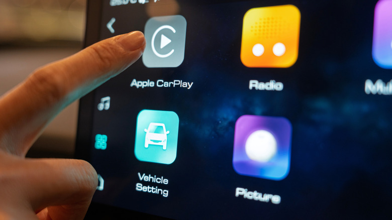 The Apple CarPlay menu being accesses by a driver